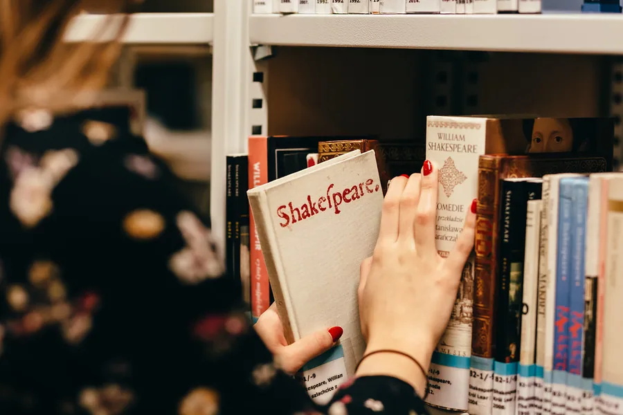 Étudiant tunisien révisant l'anglais avec des livres et un ordinateur