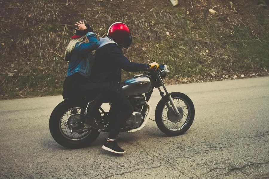 Motard tenant son casque à côté de sa moto