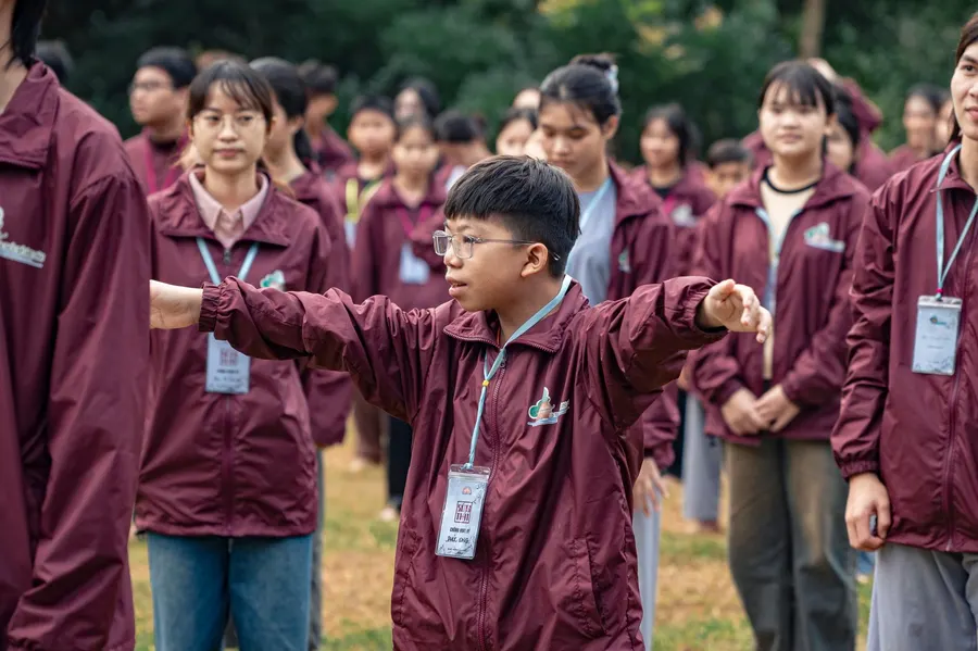 Teenagers engaging in a coordinated outdoor exercise in matching jackets.