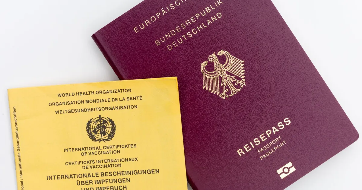 Close-up view of a German passport and WHO vaccination card, ideal for travel themes.