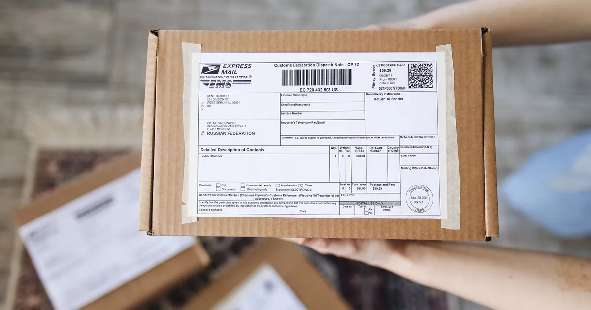 Top view of hands holding an express mail parcel with a customs declaration.