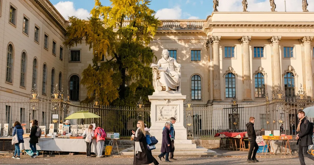 Street scene at Humboldt University with market stalls and pedestrians in Berlin.