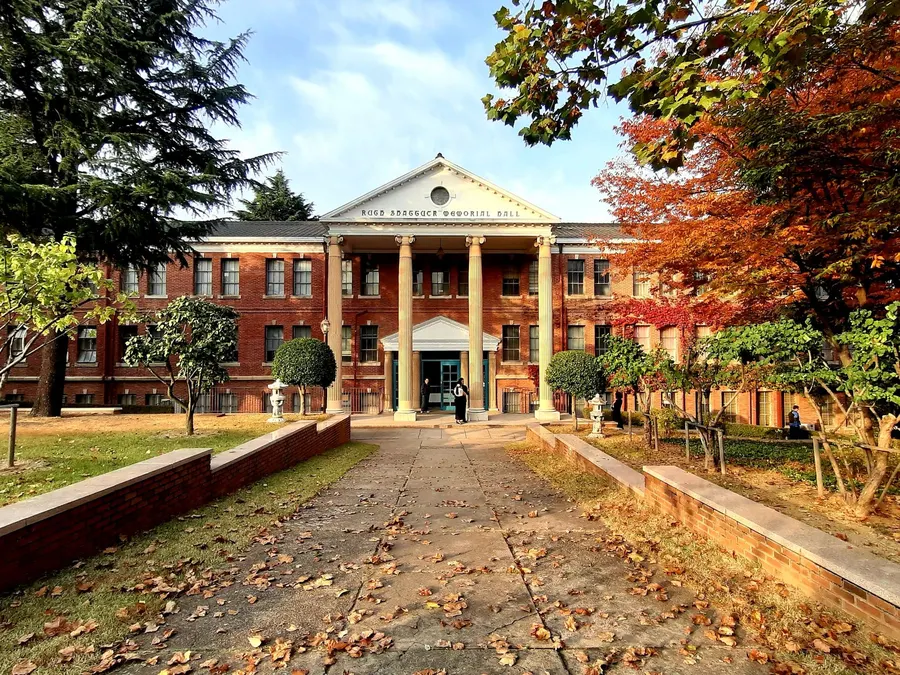A beautiful university building in Daegu, South Korea, surrounded by autumn foliage.