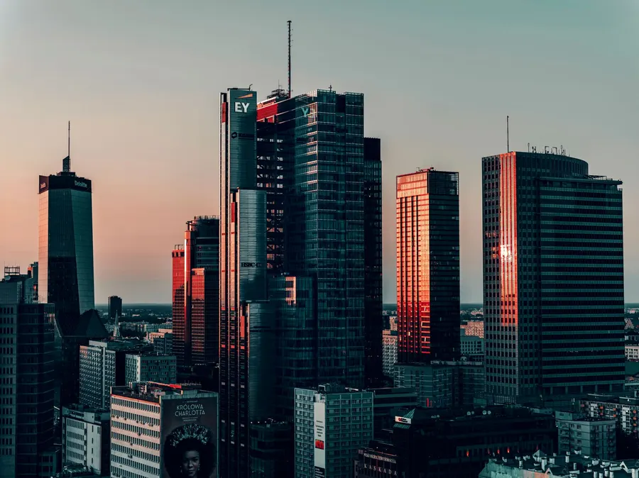 A stunning view of Warsaw's modern office buildings at sunset, showcasing city life and architecture.