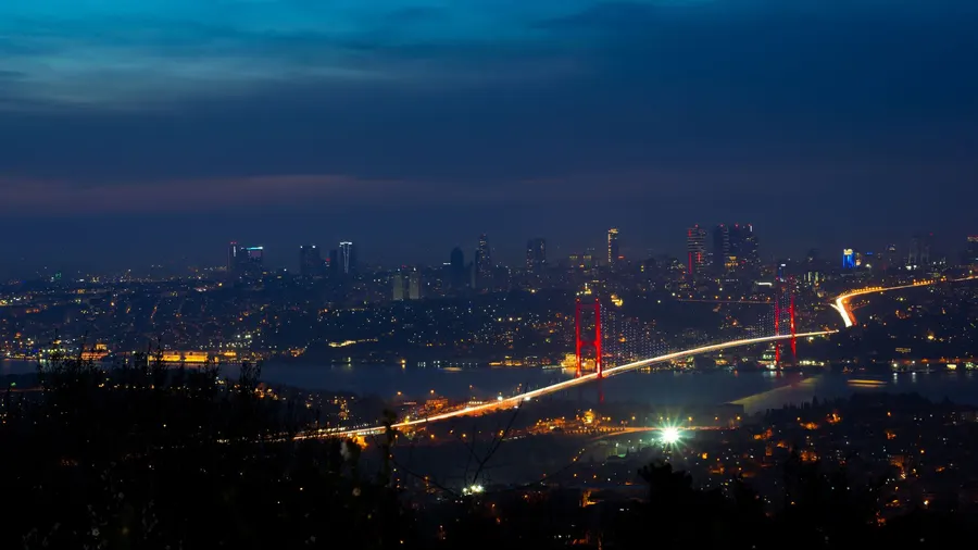 Illuminated Bosphorus Bridge and Istanbul cityscape captured at night creating a breathtaking urban scene.