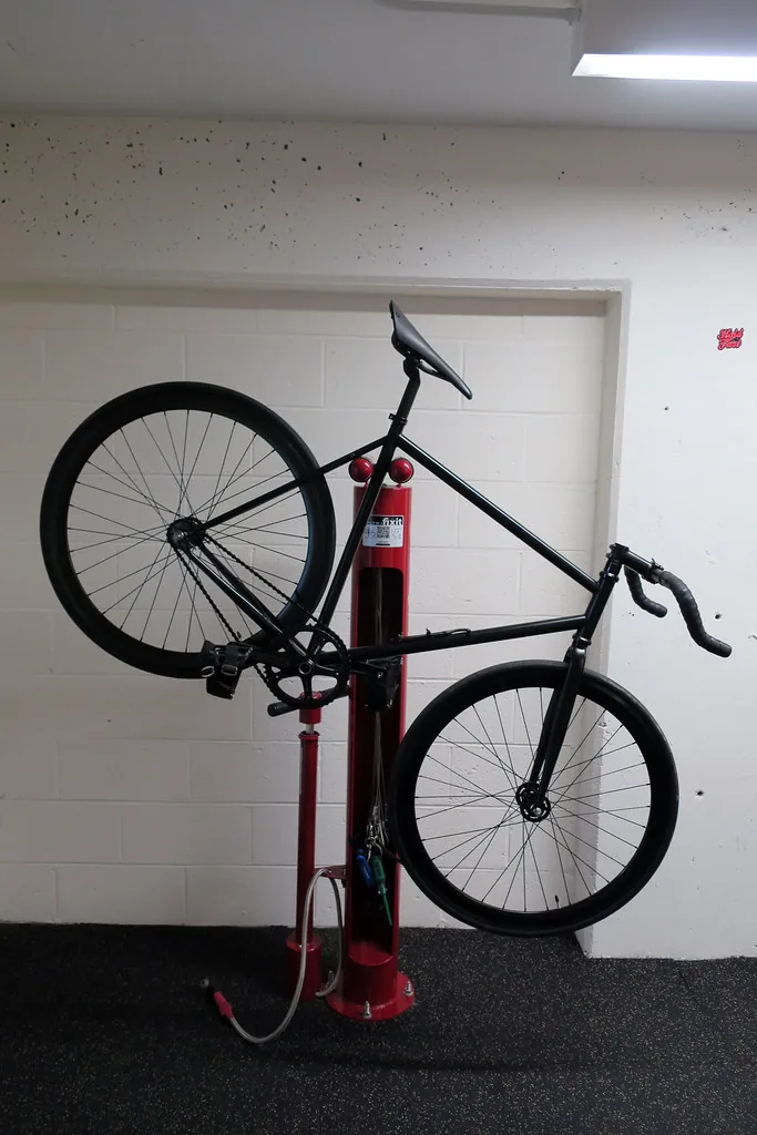 Mécanicien réparant une chaîne de vélo sur un pied d'atelier