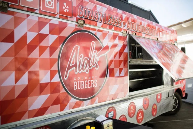 Préparation de burgers sur la plancha dans la cuisine d'un food truck