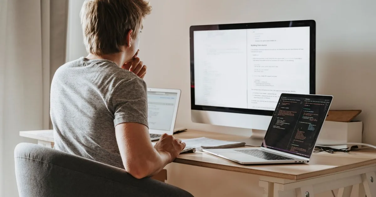 Ingénieur informatique tunisien travaillant sur plusieurs écrans