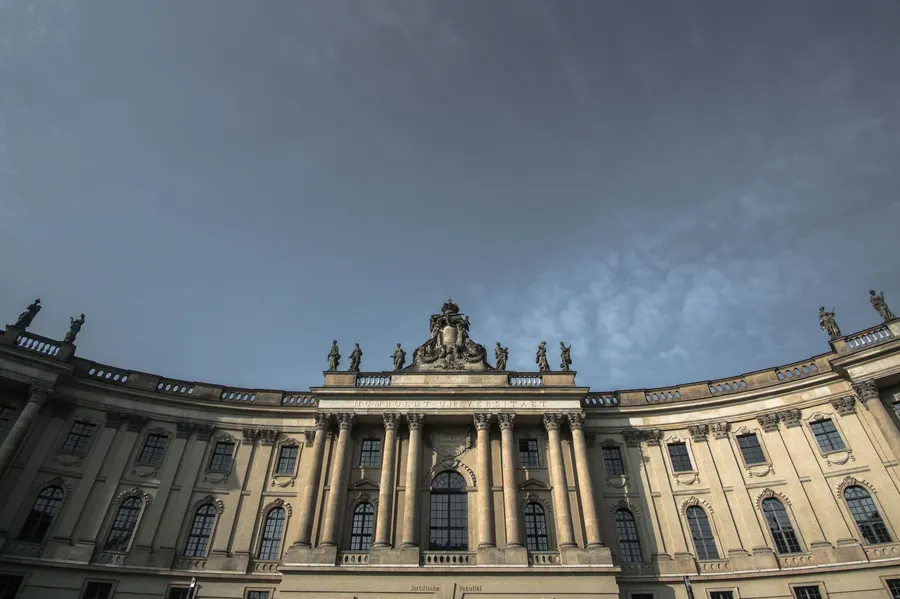 Stunning low-angle view of Humboldt University's historic facade against a cloudy sky in Berlin, Germany.