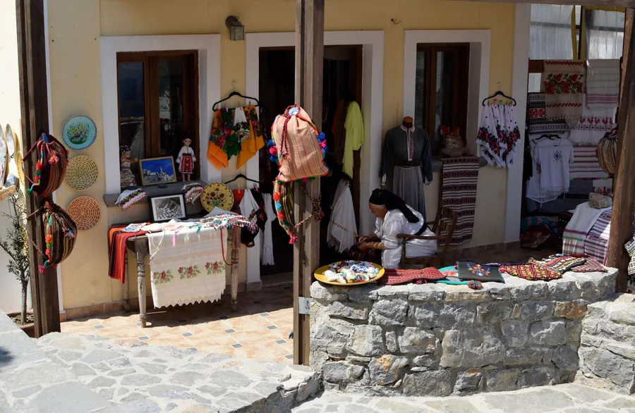 Outdoor market stall showcasing colorful handmade crafts and textiles, creating a vibrant and artistic atmosphere.